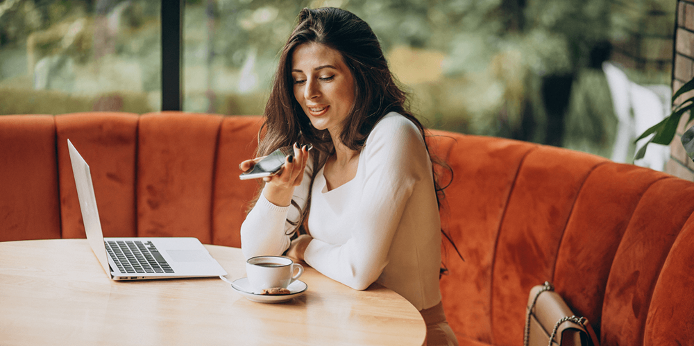 Restaurant operator using AI tools on a laptop and phone to manage guest communications