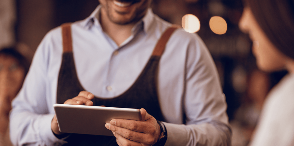 Restaurant server managing reservations on a tablet during service