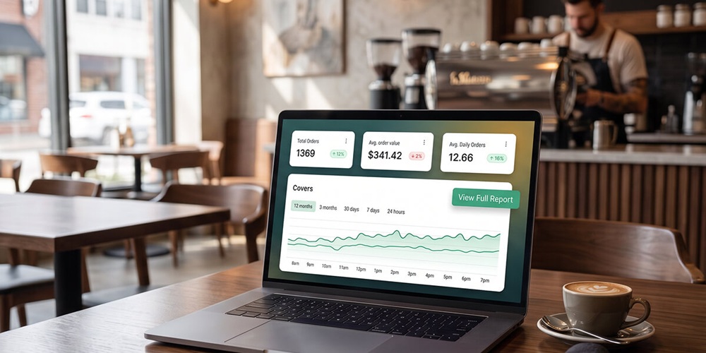 Laptop on a café table showing a restaurant analytics dashboard with covers, average order value, and daily order trends