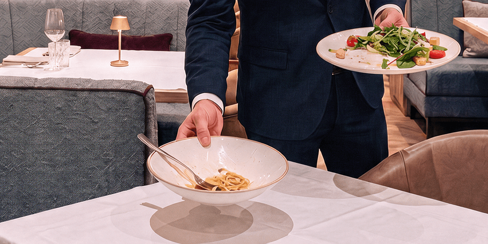 Plate waste in a restaurant, with nearly uneaten pasta returned at the end of service, one of the most common and least tracked sources of food waste