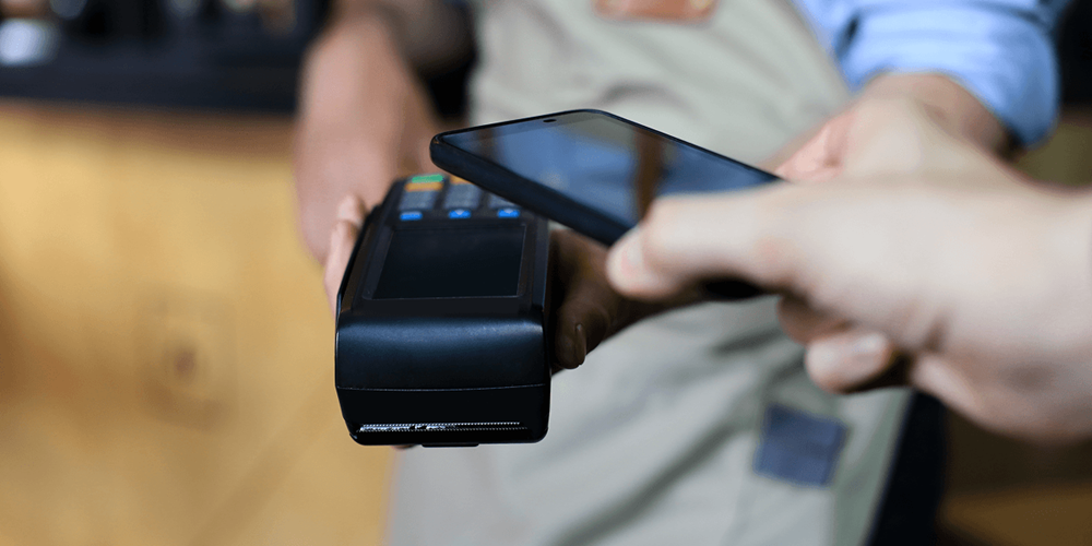 Contactless payment being processed on a portable terminal, showing restaurant payment flexibility at the point of settlement.